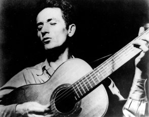 This is an undated photograph of folk singer Woody Guthrie, singing a song and playing his guitar. Guthrie has written hundreds of songs, celebrating migrant workers, pacifists, and underdogs. Two of his well-known songs are "So Long, It's Been Good to Know You," and "This Land is Your Land." (AP Photo)